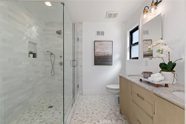 full bathroom featuring visible vents, double vanity, toilet, and a shower stall