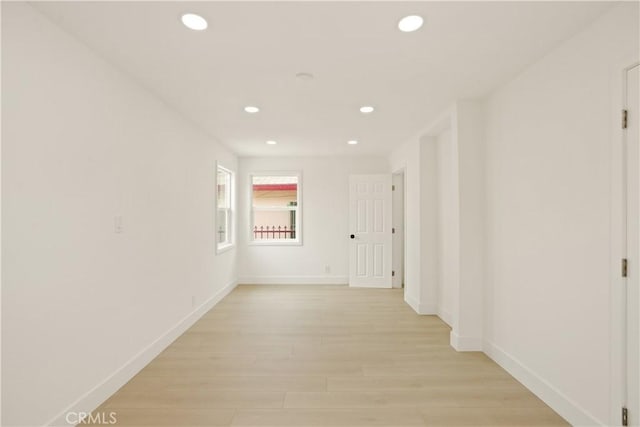 hallway with recessed lighting, baseboards, and light wood-style floors