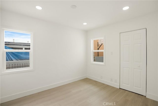 unfurnished room with recessed lighting, baseboards, a healthy amount of sunlight, and light wood-type flooring
