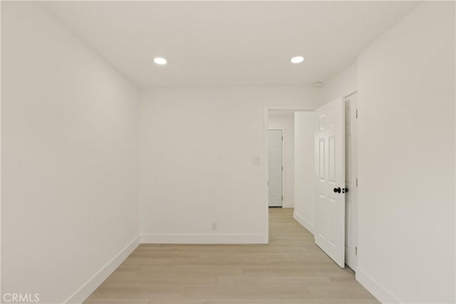 empty room featuring light wood-type flooring, recessed lighting, and baseboards