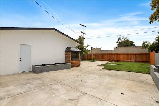 view of patio / terrace with fence and exterior fireplace