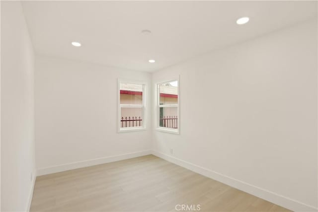 empty room featuring light wood-style floors, recessed lighting, and baseboards