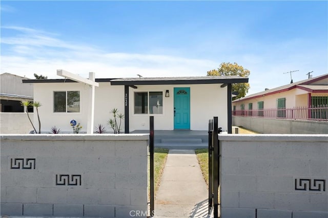 view of front facade with a fenced front yard and stucco siding