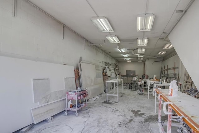 misc room with a garage and concrete floors