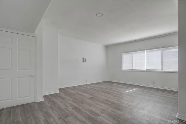 unfurnished room with baseboards and wood finished floors