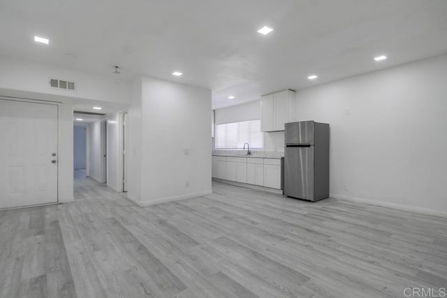 interior space with baseboards, light wood-type flooring, recessed lighting, and visible vents