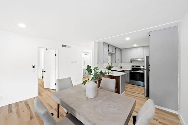 dining room with recessed lighting, baseboards, light wood-type flooring, and visible vents