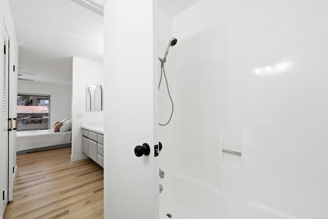 full bath featuring connected bathroom, shower / bath combination, wood finished floors, and vanity