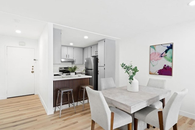 dining area with light wood-style floors, baseboards, and recessed lighting