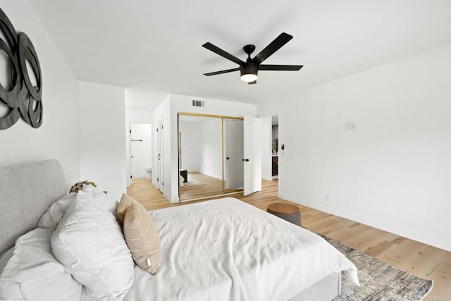 bedroom with a ceiling fan, visible vents, baseboards, a closet, and light wood-style flooring