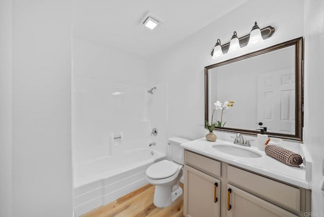 bathroom with toilet, shower / tub combination, wood finished floors, and vanity