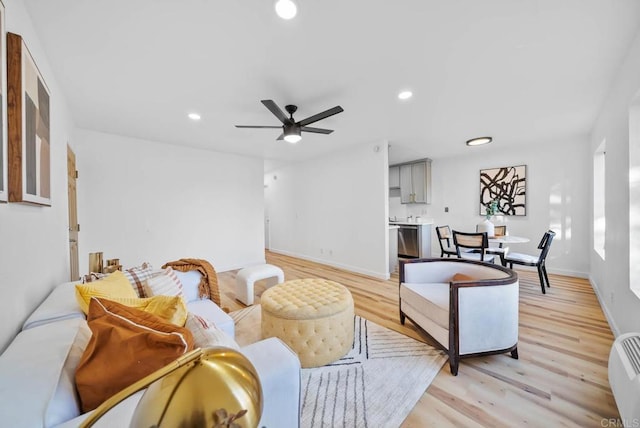 living area featuring baseboards, a ceiling fan, recessed lighting, and light wood-style flooring