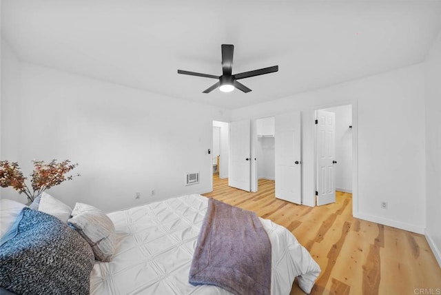 bedroom with a ceiling fan, visible vents, baseboards, a spacious closet, and light wood-style flooring