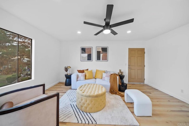 living area featuring recessed lighting, a ceiling fan, light wood-style flooring, and baseboards