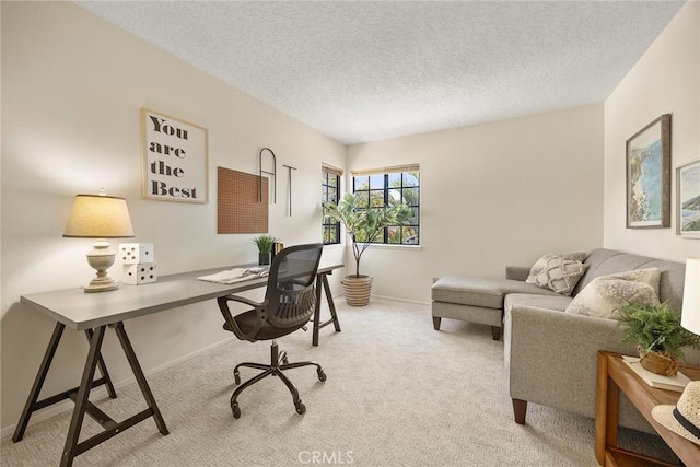 carpeted office space with a textured ceiling and baseboards