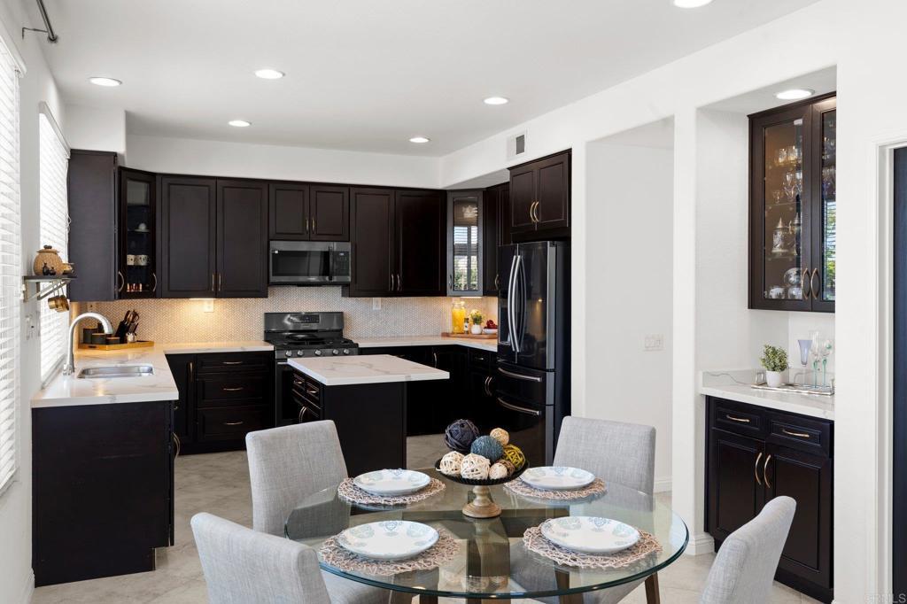 kitchen with a sink, a center island, decorative backsplash, and stainless steel appliances