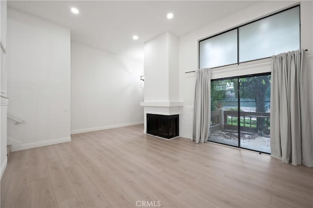 8535 Village Ln, Rosemead, CA 91770 - unfurnished living room with light wood-style floors, a multi sided fireplace, baseboards, and recessed lighting