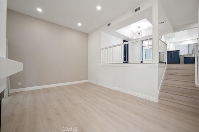 8535 Village Ln, Rosemead, CA 91770 - unfurnished living room with a notable chandelier, light wood-style floors, stairs, recessed lighting, and baseboards
