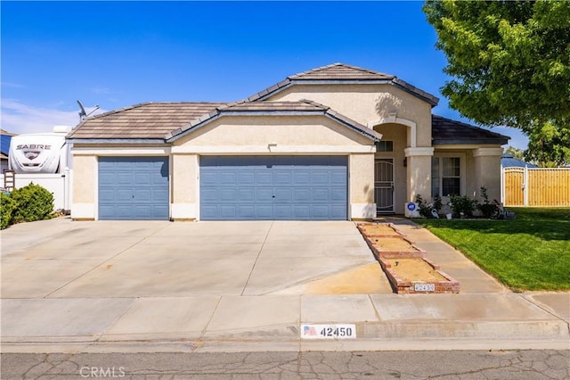 42450 Blossom Dr, Lancaster, CA 93536 - mediterranean / spanish home featuring fence, a front lawn, concrete driveway, an attached garage, and stucco siding