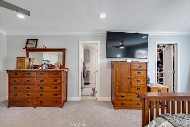 bedroom with a walk in closet, baseboards, ornamental molding, light carpet, and recessed lighting