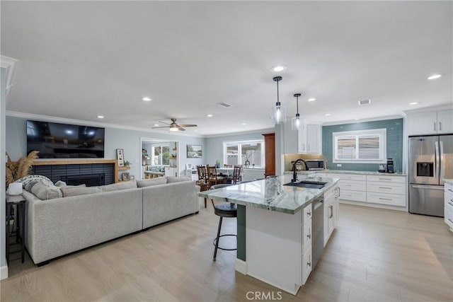 kitchen with stainless steel appliances, recessed lighting, a sink, and a fireplace