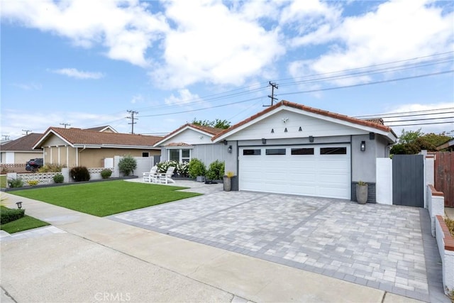 view of front of property with decorative driveway, a garage, a front lawn, and fence