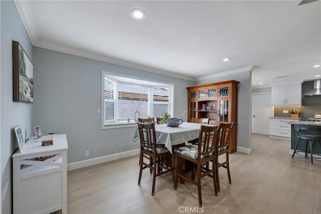 dining room featuring recessed lighting, light wood-style flooring, crown molding, and baseboards