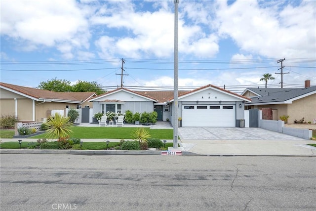 ranch-style house with decorative driveway, an attached garage, fence, and a front lawn
