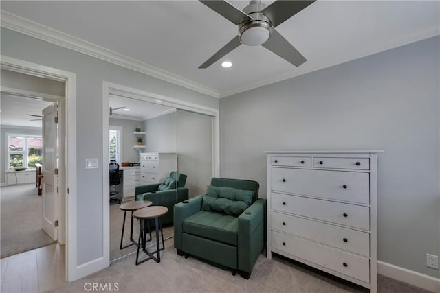 living area featuring crown molding, a ceiling fan, baseboards, and light carpet