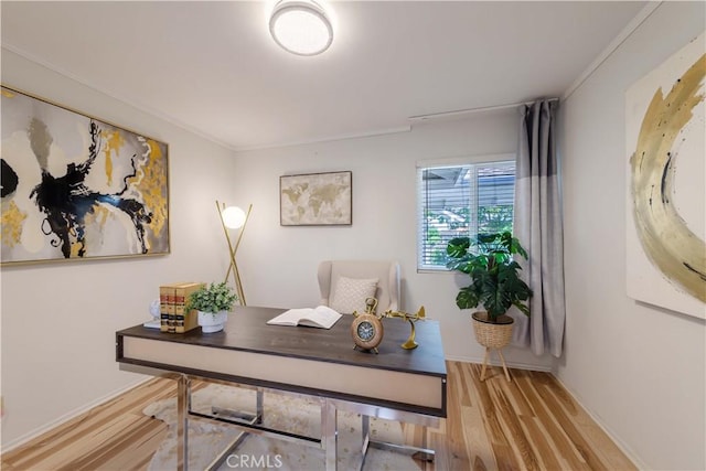 office featuring light wood-style floors, baseboards, and crown molding