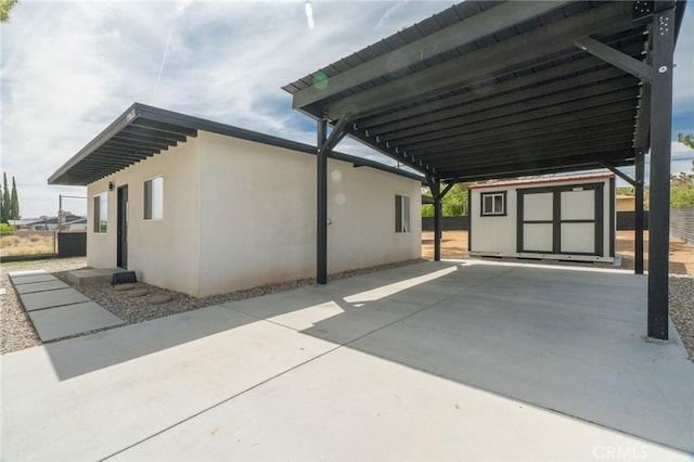 view of side of property featuring an outdoor structure, a shed, fence, and a carport