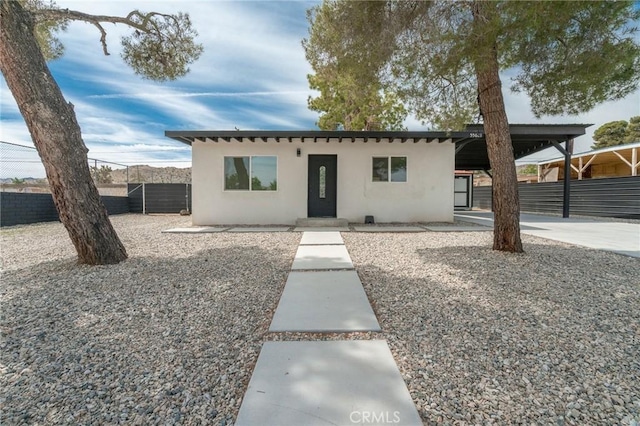 bungalow featuring fence and stucco siding