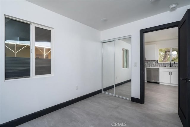 unfurnished bedroom with a closet and baseboards