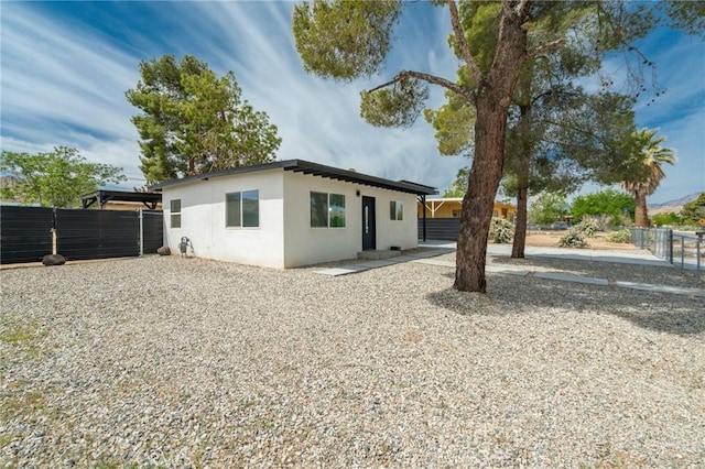 back of property with fence and stucco siding