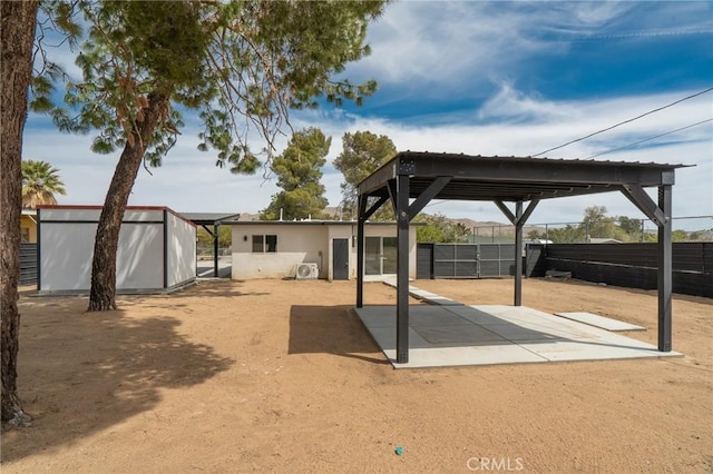 view of patio featuring a storage shed, fence, and an outbuilding