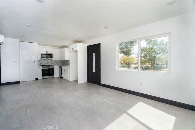 unfurnished living room with baseboards