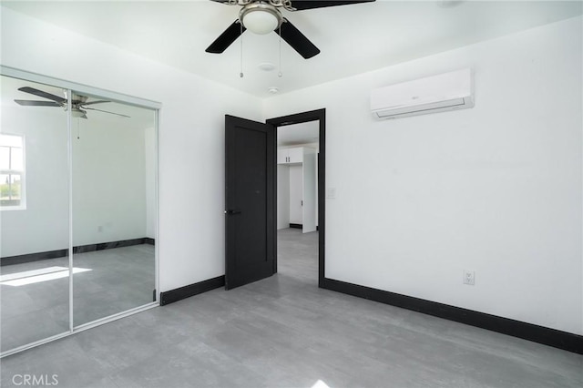 unfurnished bedroom featuring an AC wall unit, baseboards, ceiling fan, and a closet