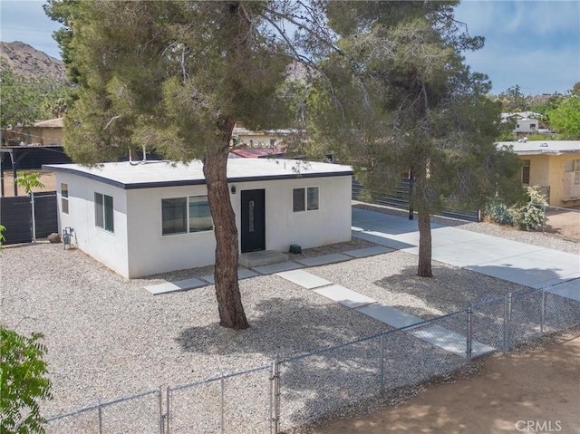 rear view of house with stucco siding and fence private yard