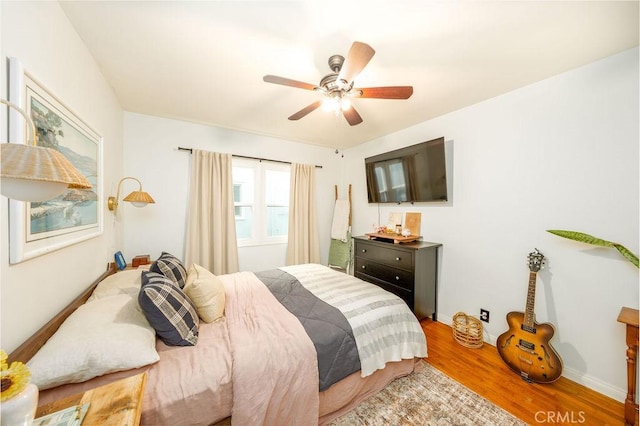 bedroom featuring baseboards, ceiling fan, and wood finished floors