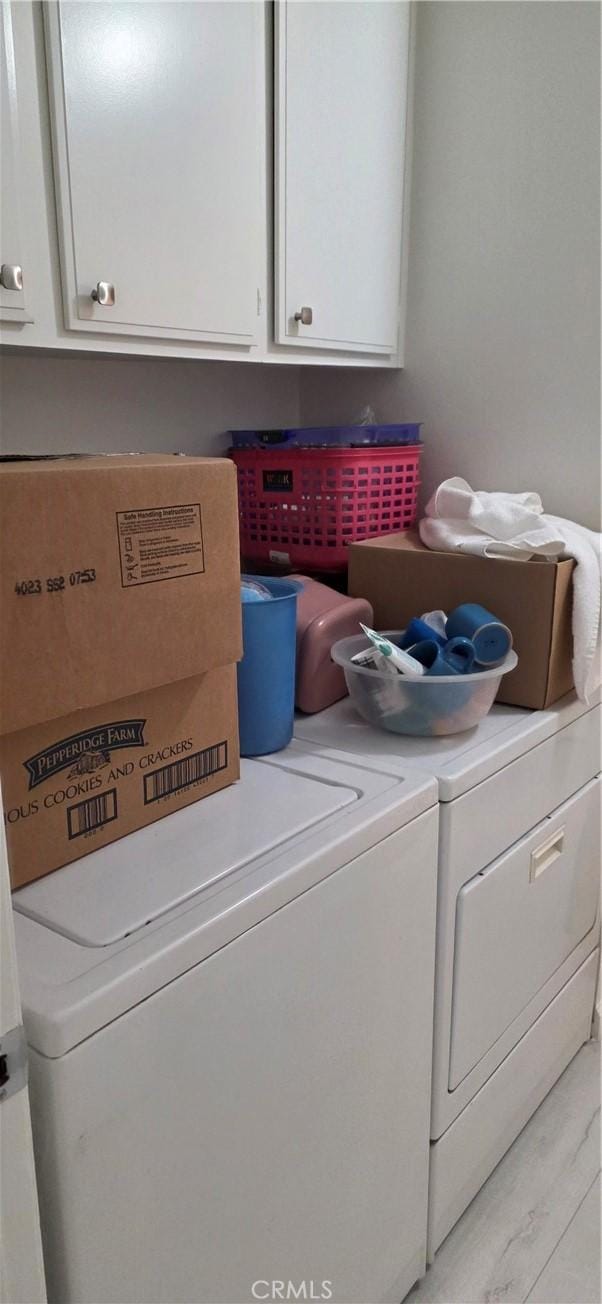 laundry room with washing machine and dryer and cabinet space