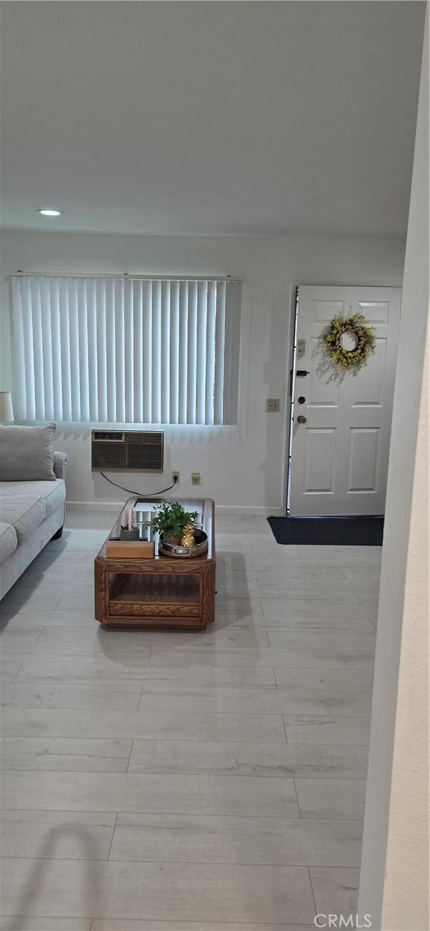 living room featuring baseboards and a wall unit AC