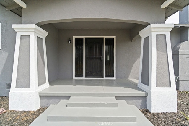 view of exterior entry with stucco siding
