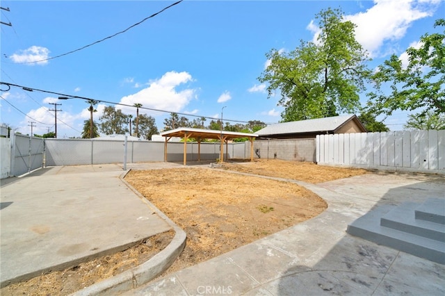 view of yard featuring a fenced backyard, a detached carport, and a patio area