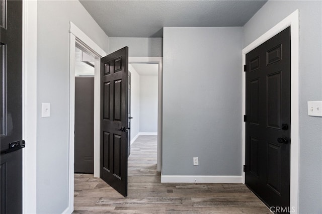 interior space featuring baseboards and wood finished floors