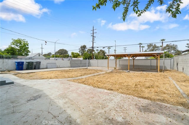 view of yard featuring a fenced backyard, a patio area, and a carport