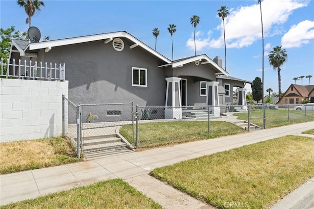 view of front of property with fence private yard, a front yard, stucco siding, a chimney, and a gate