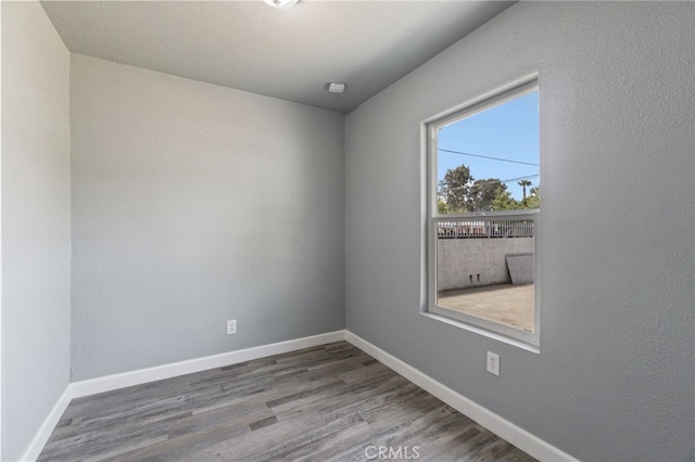 empty room with baseboards and wood finished floors