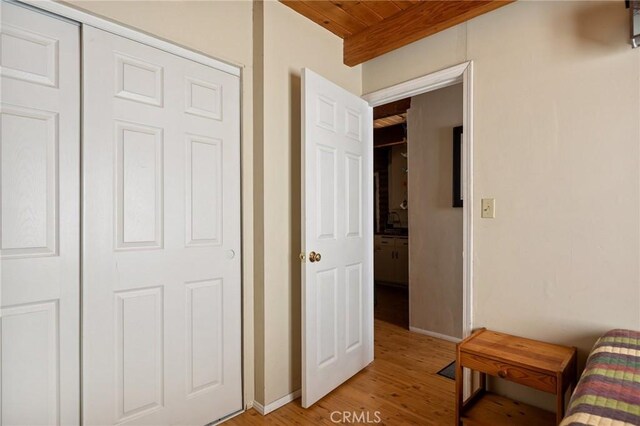 bedroom with wooden ceiling, baseboards, and light wood-type flooring
