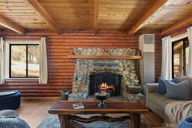 living room with beamed ceiling, a wealth of natural light, and wood finished floors