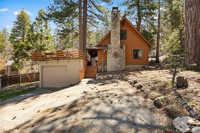 rustic home featuring fence, driveway, and a chimney